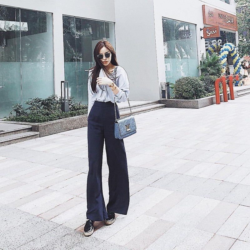 Quần ống loe liên tục được Kỳ Duyên trưng dụng trong tuần lễ Giáng Sinh. Quý cô 21 tuổi còn mix phiên bản quần xanh hải quân với áo blouse, phối với túi Twist từ thương hiệu Louis Vuitton danh tiếng.