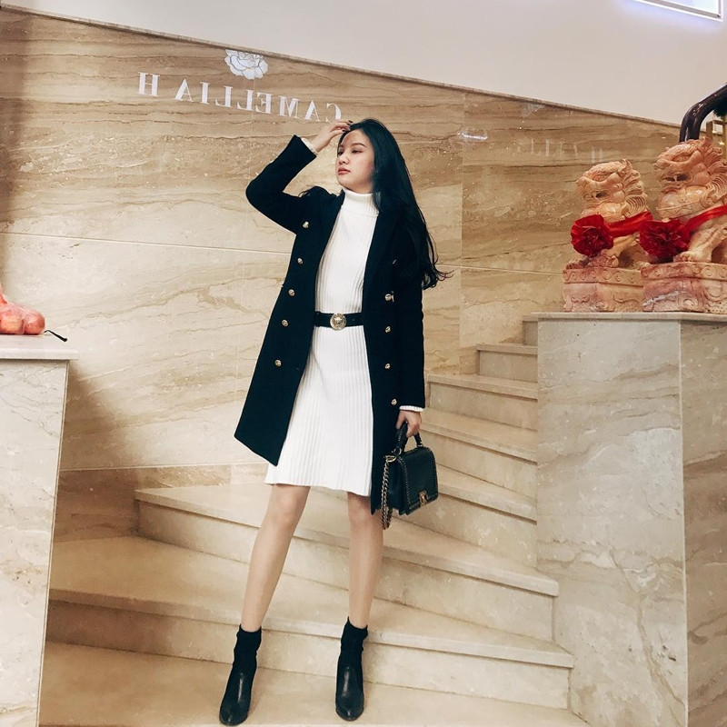 Cũng mê đắm cặp màu trắng đen, Hạnh Sino lại chọn style nữ tính, mềm mại hơn khi chưng diện mẫu đầm trắng, dùng thắt lưng tạo điểm chít eo. Nữ ca sỹ kết hợp trang phục này cùng áo khoác dáng dài, phối với boots da và túi Chanel tiệp màu đen, càng khiến vẻ ngoài thêm thời thượng.