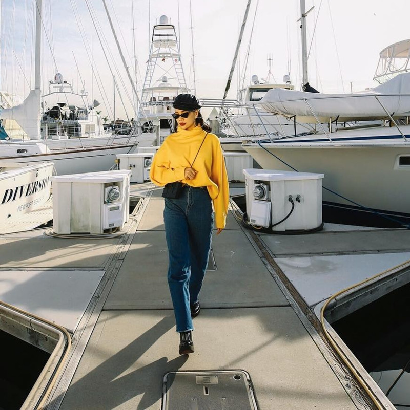 Trà Ngọc Hằng đem đến ''làn gió mới'' cho phong cách retro với lựa chọn quần jeans cạp cao và áo len cổ lọ phủ sắc vàng chói mắt. Sự tương phản màu sắc không chỉ là hiệu ứng giúp các món đồ làm nổi bật lẫn nhau mà còn đem đến sức hút mạnh mẽ cho người đẹp.