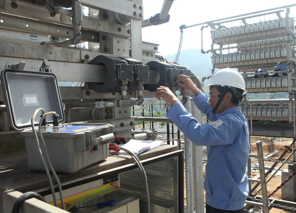 Công nhân Tổng công ty Điện lực miền Trung thí nghiệm thiết bị trước khi đóng điện. (Ảnh: Ngọc Hà/TTXVN)