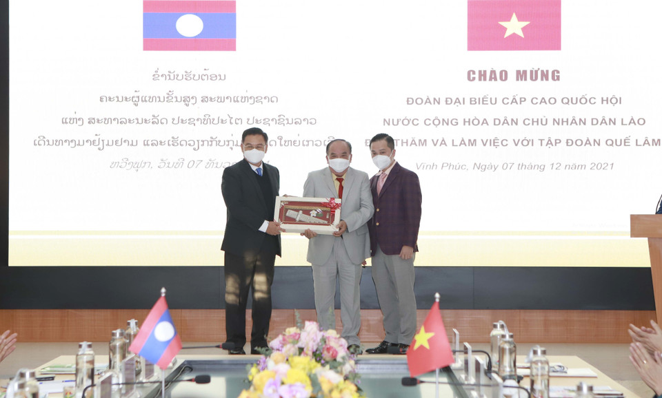 Chủ tịch Quốc hội nước Cộng hòa Dân chủ Nhân dân Lào Xaysomphone Phomvihane (trái) tặng quà lưu niệm cho lãnh đạoTập đoàn Quế Lâm. (Ảnh: Hoàng Hùng/TTXVN)