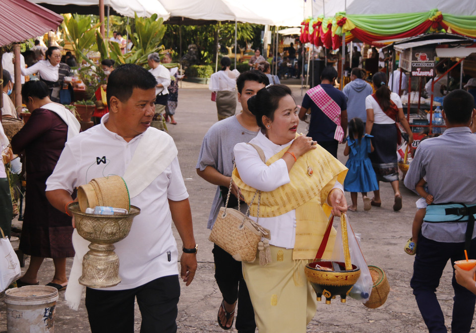 Người dân Lào đủ mọi lứa tuổi trong các bộ trang phục truyền thống đổ tới các ngôi chùa gần nhà để dự các nghi lễ trong Boun Okphansa. (Ảnh: Phạm Kiên/TTXVN)