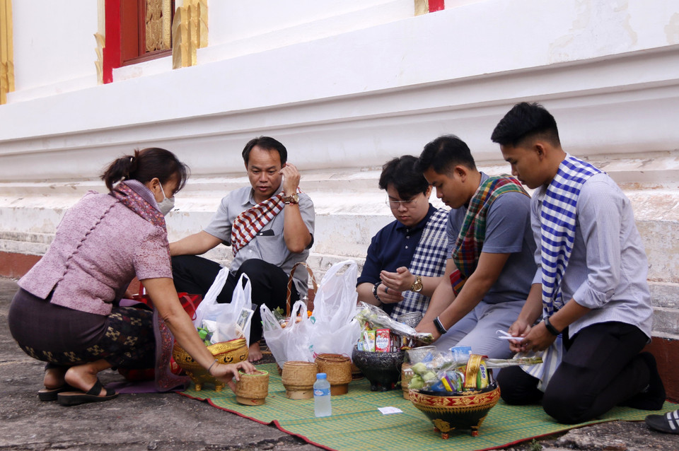 Một gia đình người Lào chuẩn bị các đồng cúng dường trước khi tham gia dự các nghi lễ trong Boun Okphansa. (Ảnh: Phạm Kiên/TTXVN)