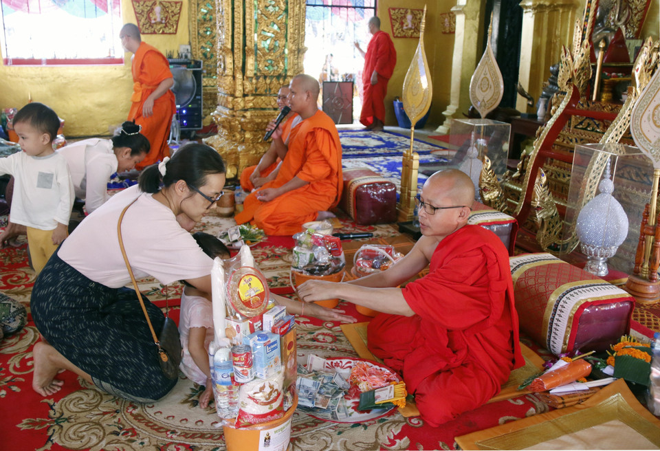 Sau khi thực hiện nghi thức Tatbath, nhiều gia đình cũng tranh thủ buộc chỉ cổ tay để cầu phúc cho các thành viên trong nhà. (Ảnh: Phạm Kiên/TTXVN)