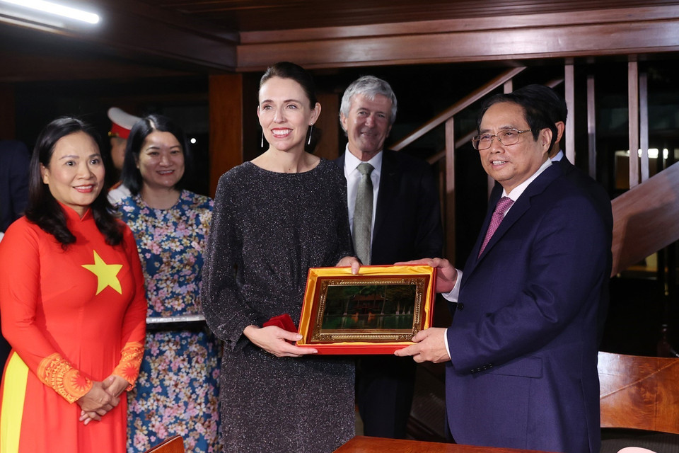 Thủ tướng Phạm Minh Chính trao quà lưu niệm tặng Thủ tướng New Zealand Jacinda Ardern. (Ảnh: Dương Giang/TTXVN)