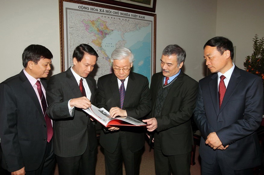 Tổng Bí thư Nguyễn Phú Trọng và các đồng chí lãnh đạo TTXVN xem các ấn phẩm mới được phát hành của TTXVN (16/2/2015). (Ảnh: Trí Dũng/TTXVN)