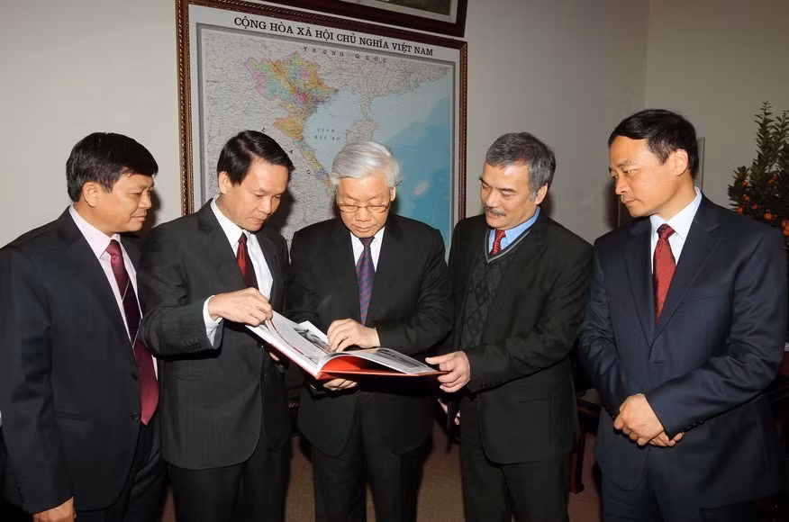 Tổng Bí thư Nguyễn Phú Trọng và các đồng chí lãnh đạo TTXVN xem các ấn phẩm mới được phát hành của TTXVN (16/2/2015). (Ảnh: Trí Dũng/TTXVN)