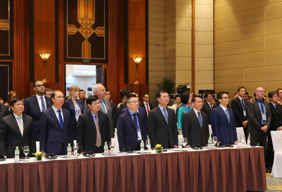 Phó Thủ tướng Vũ Đức Đam, Bộ trưởng Bộ Thông tin và Truyền thông Nguyễn Mạnh Hùng, Tổng Giám đốc TTXVN Nguyễn Đức Lợi và các đại biểu làm lễ chào cờ. (Ảnh: TTXVN)