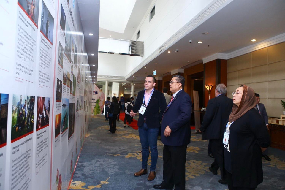 Đại biểu đoàn Hãng thông tấn Bernama của Malaysia tham quan trưng bày giới thiệu về các hãng thông tấn thành viên OANA. (Ảnh: Minh Quyết/TTXVN)