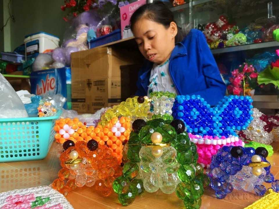 Chị Trần Kim Phượng (40 tuổi) ở phường Lê Bình, quận Cái Răng, thành phố Cần Thơ, nạn nhân chất độc da cam. Dù cơ thể tàn tật do nhiễm độc, sức khỏe yếu nhưng chị đã vượt lên hoàn cảnh, quyết vươn lên theo học nghề kết cườm, tạo việc làm có thu nhập cho bản thân. (Ảnh: Thanh Liêm/TTXVN)