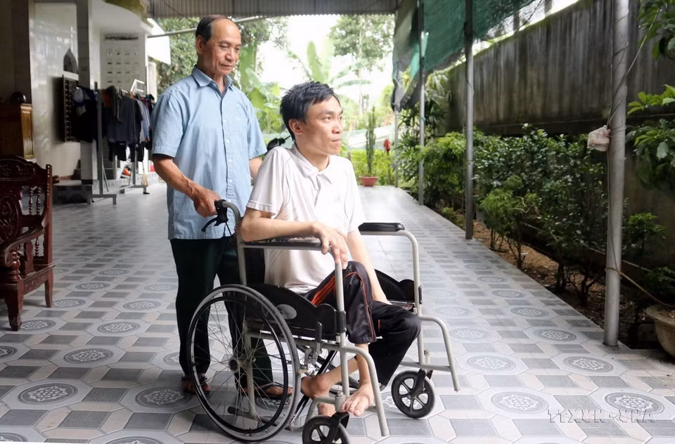 Thương binh Nguyễn Đình Duyên (bản Hốc, xã Châu Đình, huyện Quỳ Hợp, tỉnh Nghệ An) - Dũng sỹ diệt Mỹ, cùng đồng đội bắn rơi 6 máy bay địch trong một trận đấu, bên người con trai bị nhiễm chất độc da cam. (Ảnh: Văn Tý/TTXVN)