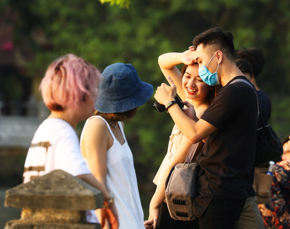 Những thanh niên Hà Nội thư giãn, tận hưởng không khí trong lành bên Hồ Tây. (Ảnh: Lâm Khánh/TTXVN)