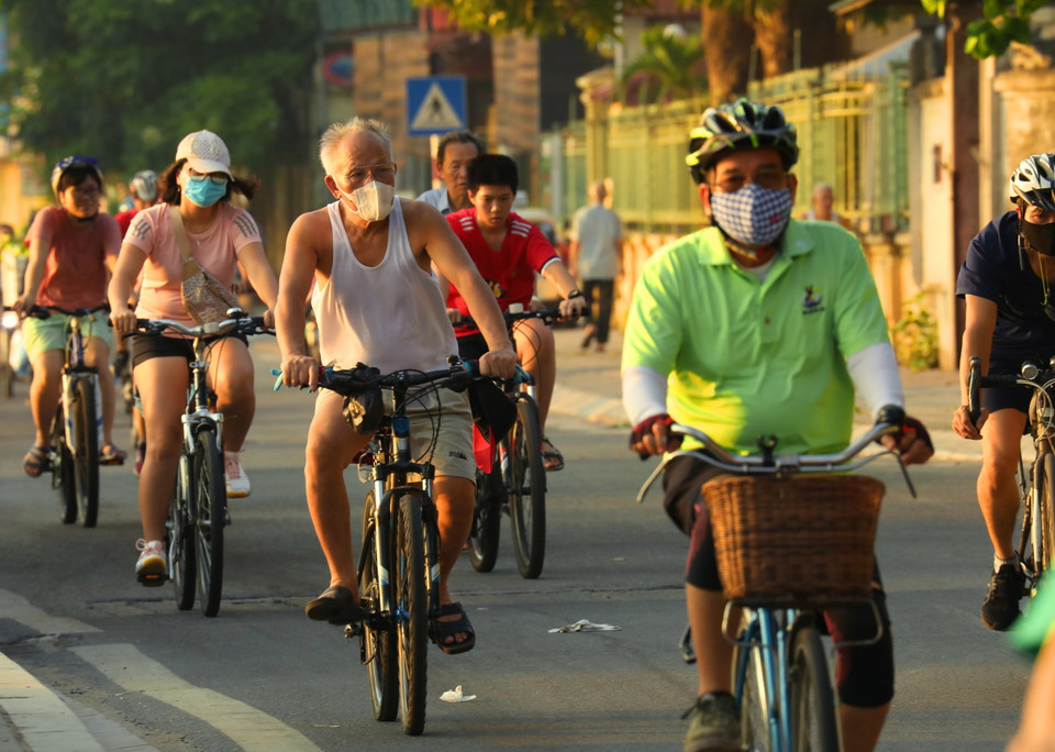 Người dân đeo khẩu trang tập thể dục sáng sớm trên phố Trích Sài, Tây Hồ. (Ảnh: Lâm Khánh/TTXVN)