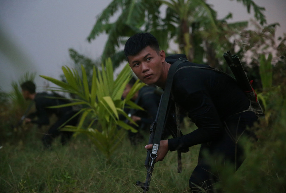 Chiến sỹ Đặc công Hải quân ẩn mình trong đêm tối, đột nhập theo đường sông đánh chiếm mục tiêu giả định. (Ảnh: Dương Giang/TTXVN)