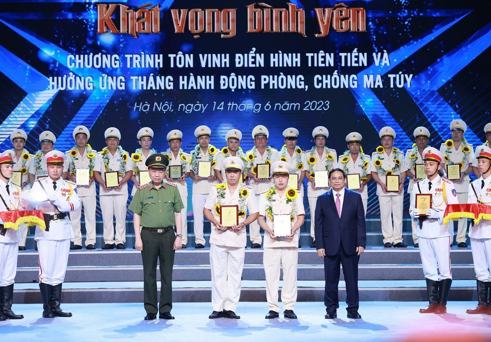 Thủ tướng Phạm Minh Chính và Đại tướng Tô Lâm trao biểu trưng vinh danh điển hình tiên tiến trong phòng, chống ma túy cho các cá nhân. (Ảnh: Dương Giang/TTXVN)