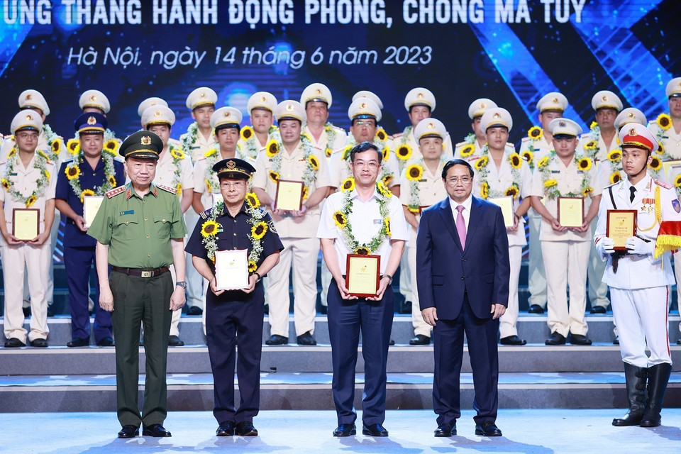 Thủ tướng Phạm Minh Chính và Đại tướng Tô Lâm, Bộ trưởng Bộ Công an trao biểu trưng vinh danh điển hình tiên tiến trong phòng, chống ma túy cho các cá nhân. (Ảnh: Dương Giang/TTXVN)
