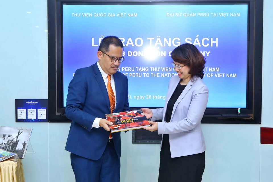 Đại biện đại sứ quán Peru tại Việt Nam Luis Tsuboyama trao tặng tượng trưng sách cho Thư viện Quốc gia Việt Nam. (Ảnh: Minh Quyết/TTXVN)