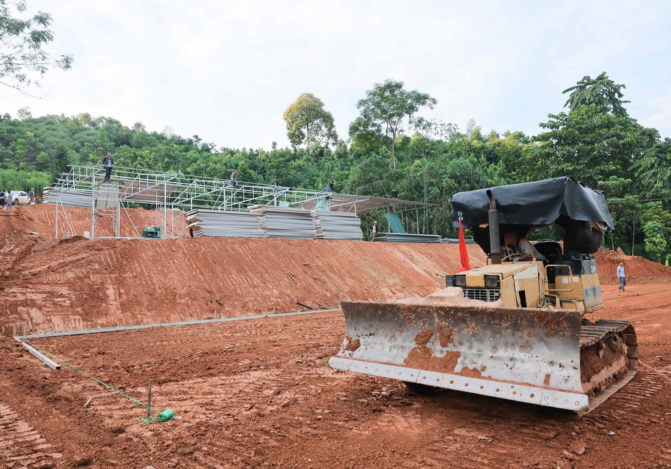 Các phương tiện máy móc được sử dụng để đẩy nhanh tiến độ thi công, sớm bàn giao nhà cho người dân thôn Làng Nủ. (Ảnh: Hoàng Hiếu/TTXVN)