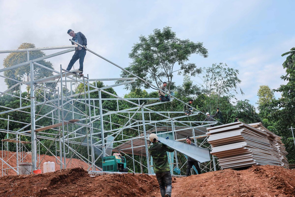 Các đơn vị thi công đang đẩy nhanh tiến độ xây lắp để người dân thôn Làng Nủ được chuyển đến khu nhà ở tạm trong ngày 21/9. (Ảnh: Hoàng Hiếu/TTXVN)