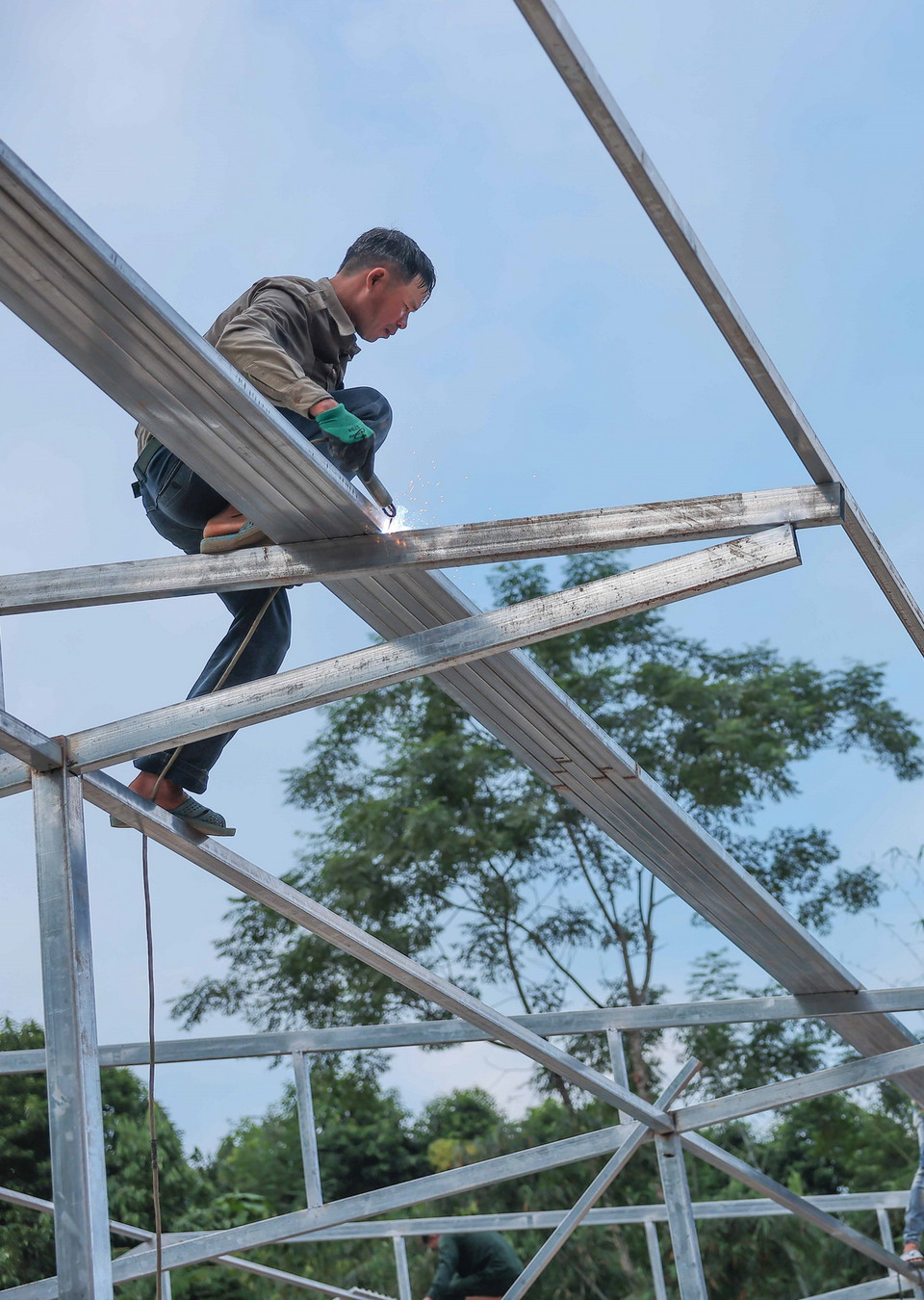 Công nhân thi công xây lắp nhà ở tạm cho người dân thôn Làng Nủ. (Ảnh: Hoàng Hiếu/TTXVN)