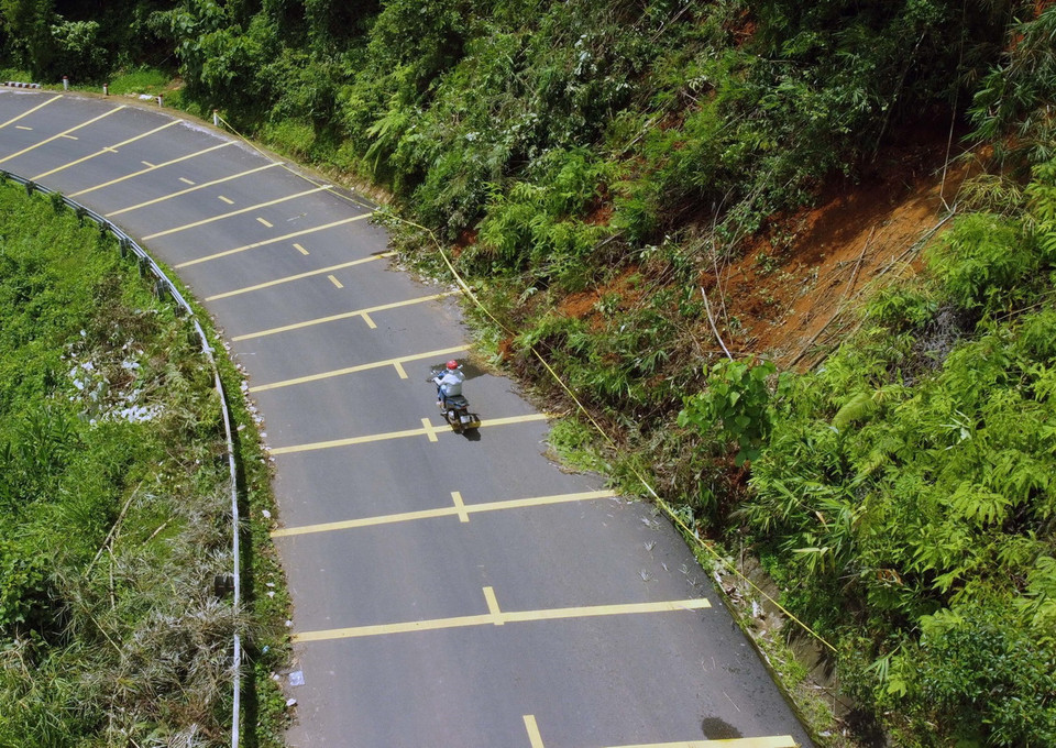 Đoạn đường sạt lở nhỏ hẹp, nhiều khúc cua gấp, dễ xảy ra tai nạn giao thông. (Ảnh: Ngọc Minh/TTXVN)
