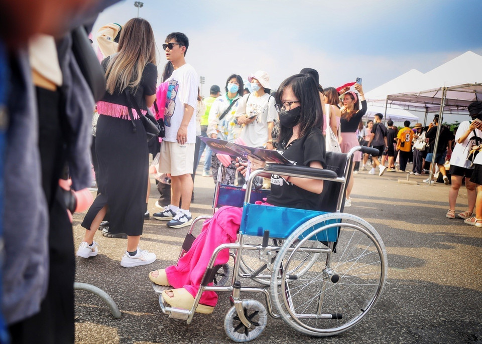 Một người hâm mộ khuyết tật ngồi xe lăn với trang phục đen-hồng đến sân vận động Mỹ Đình từ sớm để chờ vào sân tham dự Concert BlackPink. (Ảnh: Tuấn Đức/TTXVN)