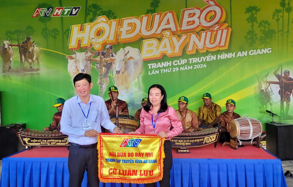 Ông Lâm Văn Bá, Phó Chủ tịch Ủy ban Nhân dân thị xã Tịnh Biên (trái) trao cờ đăng cai Hội đua bò Bảy Núi An Giang năm 2025 cho huyện Tri Tôn. (Ảnh: Công Mạo/TTXVN)