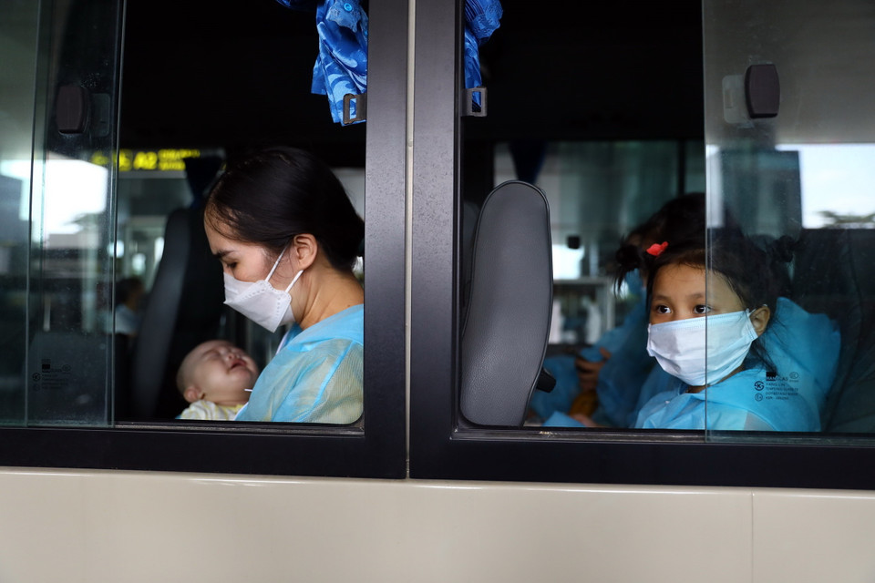 Chị Đào Thị Viên và con nhỏ mua được vé máy bay về nước sau 10 tháng kẹt tại Hàn Quốc. Chỉ trong 2 ngày, chị phải lo chi phí mua vé, làm xét nghiệm âm tính và liên hệ địa điểm cách ly tại Việt Nam. (Ảnh: Huy Hùng/TTXVN)