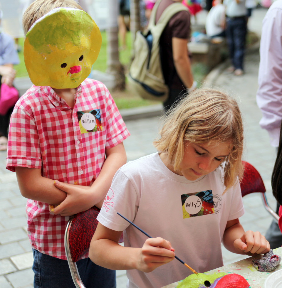 Cậu bé William ​'góp ý' với chị sau khi đã hoàn thành chiếc mặt nạ của mình.(Ảnh: Doãn Đức/Vietnam+)