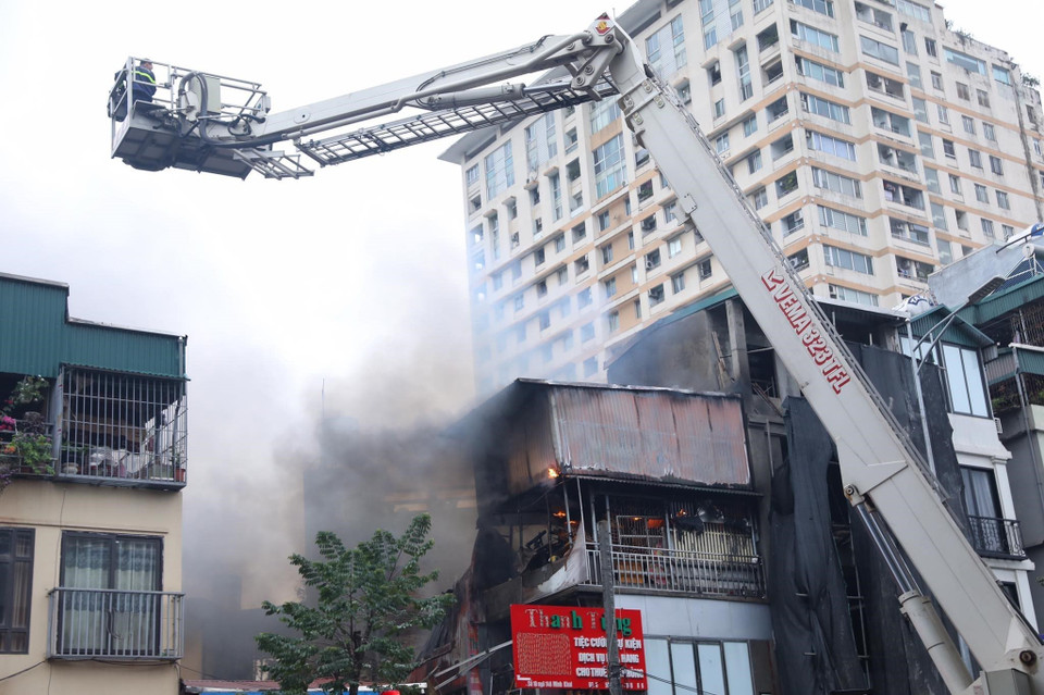 Lực lượng phòng cháy chữa cháy sử dụng xe thang để tiếp cận khống chế đám cháy. (Ảnh: Hoàng Hiếu/TTXVN)
