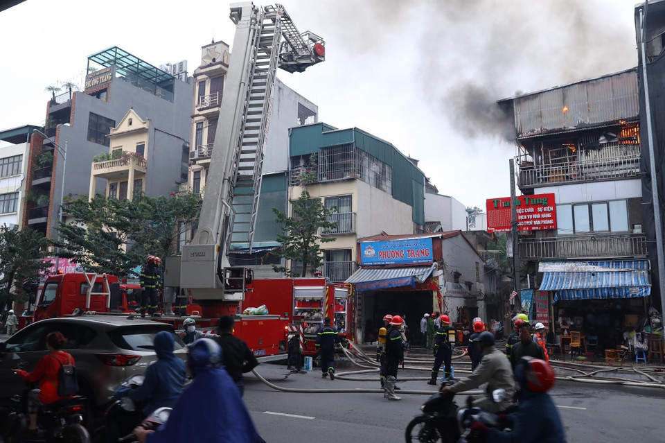 Lực lượng cảnh sát phòng cháy chữa cháy đang khẩn trương khống chế đám cháy. (Ảnh: Hoàng Hiếu/TTXVN)