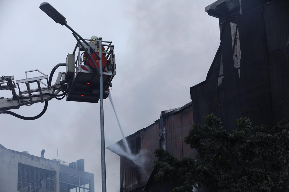 Lực lượng chức năng sử dụng xe thang tiếp cận đám cháy. (Ảnh: Hoàng Hiếu/TTXVN)