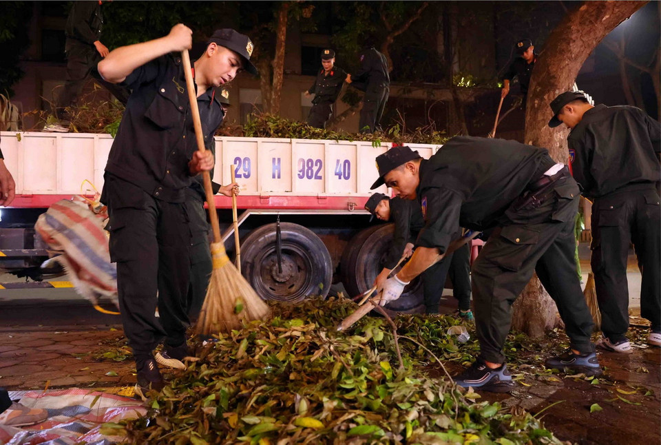 Cán bộ, chiến sỹ Cảnh sát cơ động dọn dẹp vệ sinh trên phố Phan Đình Phùng, quận Ba Đình trong đêm 14 rạng sáng 15/9. (Ảnh: Phạm Kiên/TTXVN)