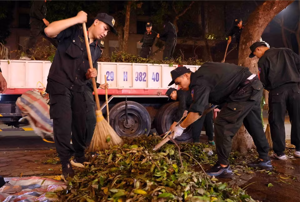 Cán bộ, chiến sỹ Cảnh sát cơ động dọn dẹp vệ sinh trên phố Phan Đình Phùng, quận Ba Đình trong đêm 14 rạng sáng 15/9. (Ảnh: Phạm Kiên/TTXVN)