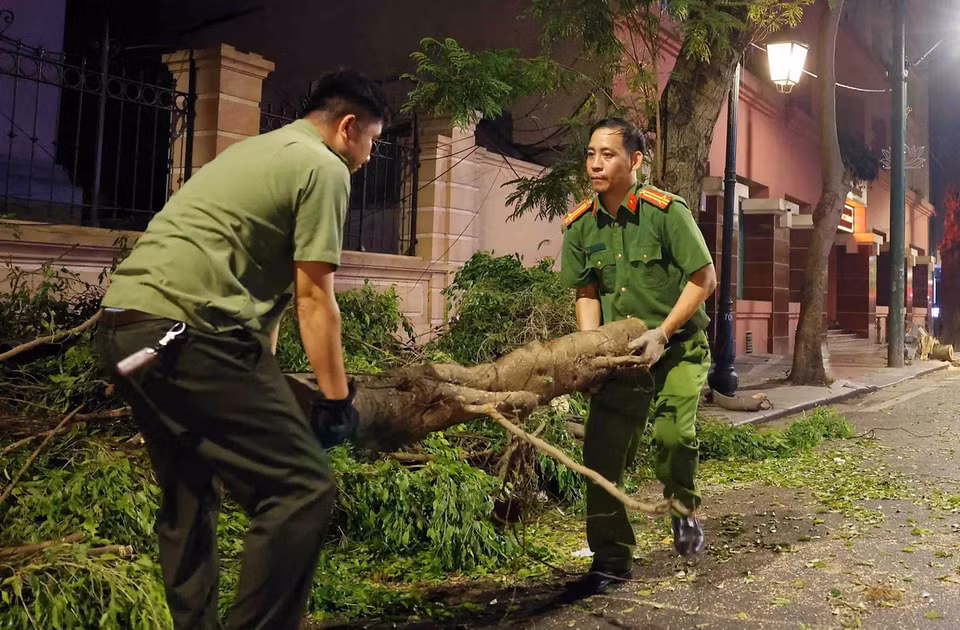 Cán bộ, chiến sỹ Công an phường Hàng Trống, Quận Hoàn Kiếm dọn dẹp cây gãy đổ sau cơn bão số 3 trên phố Tràng Thi. (Ảnh: Phạm Kiên/TTXVN)