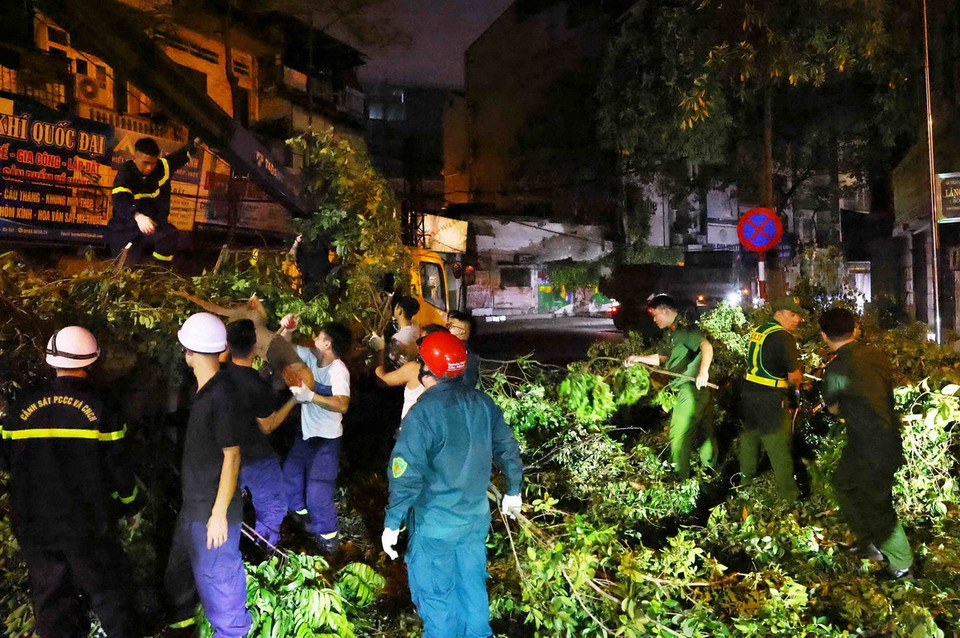 Cán bộ, chiến sỹ Công an quận Đống Đa dọn dẹp cây gãy đổ, khắc phục hậu quả bão số 3 một cách nhanh chóng và hiệu quả, đưa cuộc sống của người dân sớm trở lại bình thường. (Ảnh: Phạm Kiên/TTXVN)