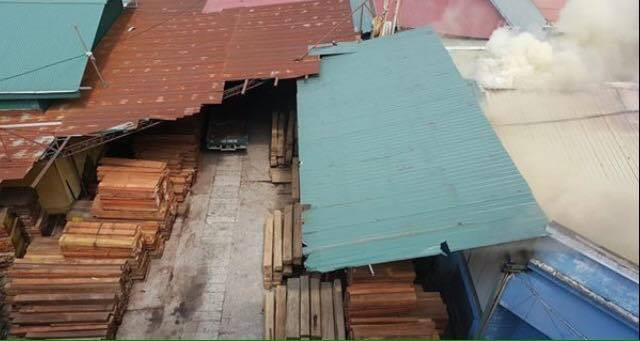 Một phần xưởng chế xuất gỗ đang bị ngọn lửa đe dọa. (Ảnh: PV/Vietnam+)