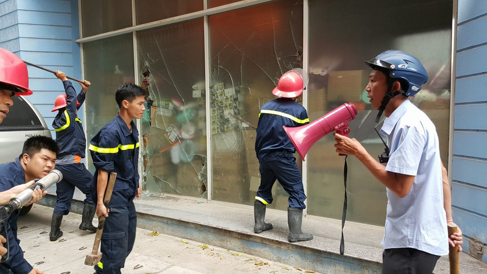 Phối hợp phá dỡ lối tiếp cận điểm cháy. (Ảnh: PV/Vietnam+)