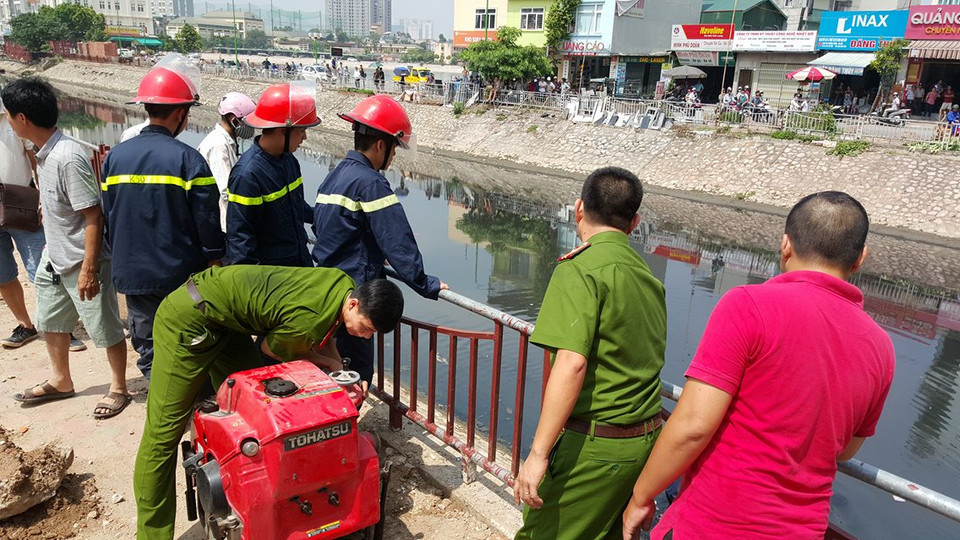 Bơm nước từ sông Tô Lịch lên để cứu hỏa. (Ảnh: PV/Vietnam+)