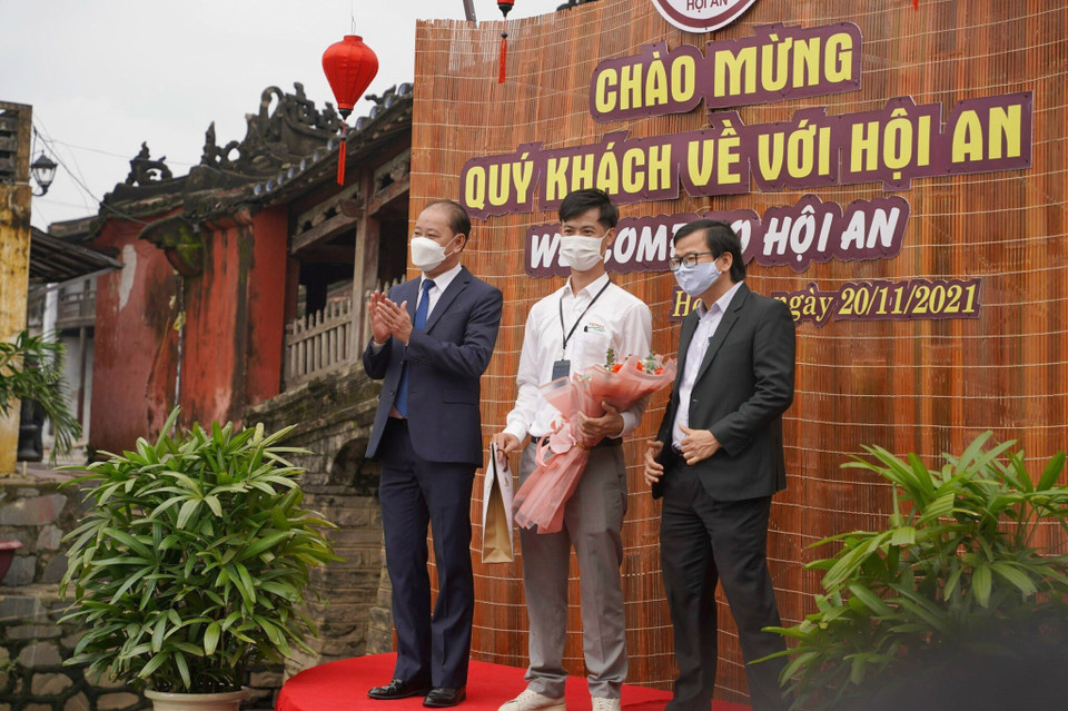Mở đầu chương trình du lịch ''Hộ chiếu vaccine'', sáng 20/11, những đoàn khách quốc tế đầu tiên đến Quảng Nam sau 2 năm bị gián đoạn do đại dịch COVID-19, đã đến tham quan phố cổ Hội An, tỉnh Quảng Nam. Trong ảnh: Chính quyền thành phố Hội An tặng quà lưu niệm cho các đoàn khách quốc tế. (Ảnh: Đoàn Hữu Trung/TTXVN)