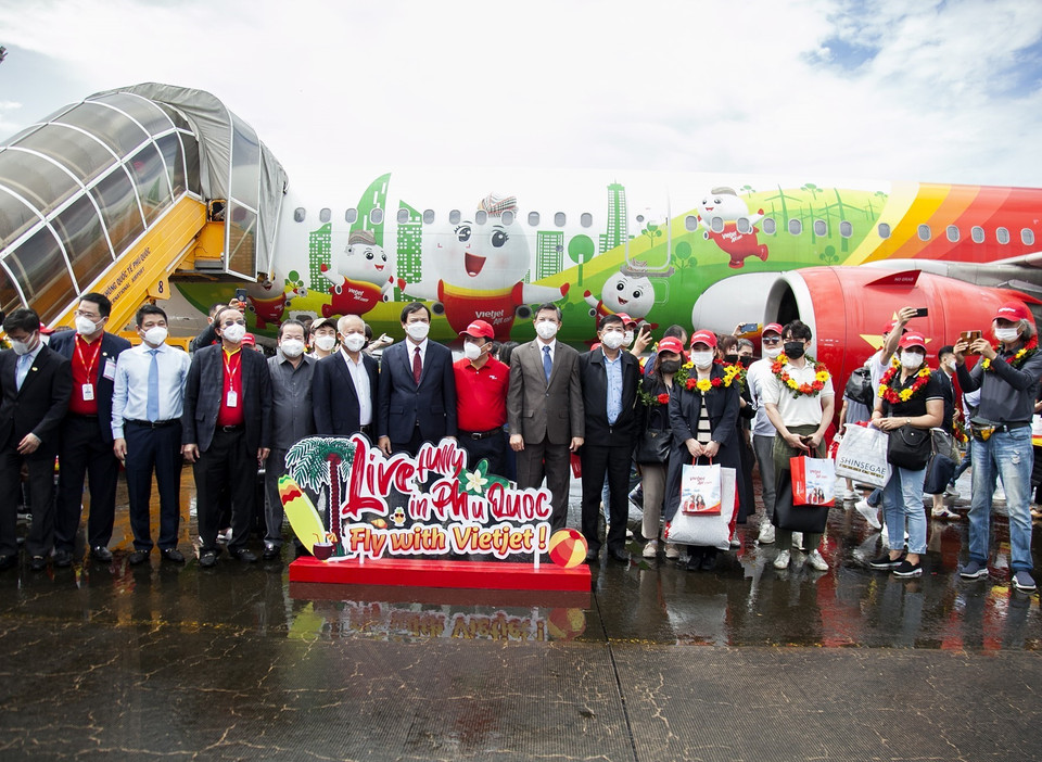 Đại diện lãnh đạo Tổng cục Du lịch, lãnh đạo tỉnh Kiên Giang, hãng hàng không Vietjet cùng những du khách quốc tế đầu tiên đến du lịch Phú Quốc sau gần hai năm du lịch Việt Nam bị ''đóng băng" do dịch COVID-19. (Ảnh: Hồng Đạt/TTXVN)