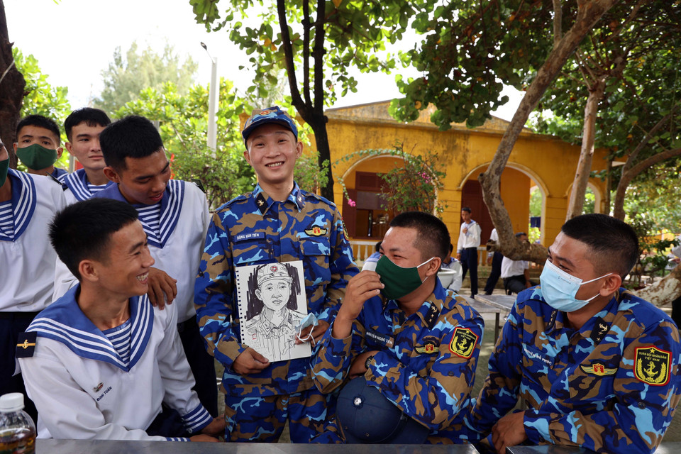 Niềm vui của các chiến sỹ Trường Sa khi được tặng tranh ký họa. (Ảnh: Diệp Trương/TTXVN)