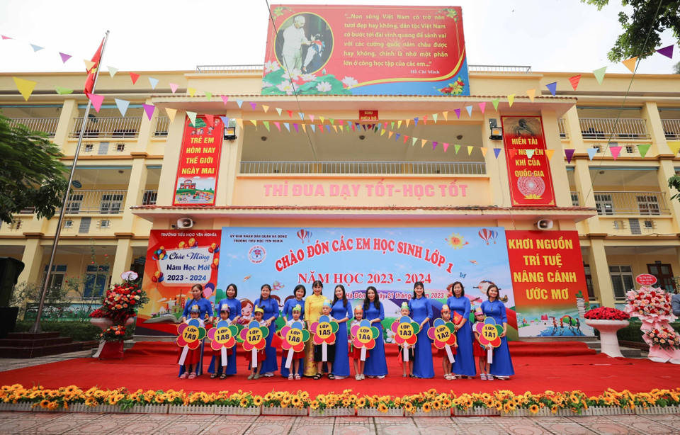 Cô giáo Trần Thị Quyên (áo vàng), Hiệu trưởng trường Tiểu học Yên Nghĩa, quận Hà Đông, trao biển lớp 1 cho cô và trò. (Ảnh: Thanh Tùng/TTXVN)