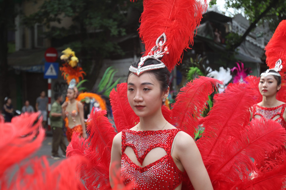 Những nữ nghệ sỹ xinh đẹp trong phút chốc đã biến con đường quanh hồ Hoàn Kiếm thành một vũ hội tràn đầy sắc màu. (Ảnh: PV/Vietnam+)