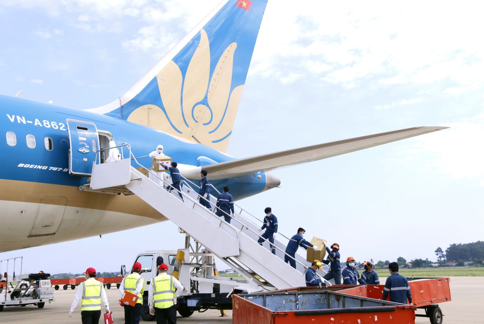 Bốc dỡ hàng hỗ trợ giúp Lào đối phó với COVID-19. (Ảnh: Phạm Kiên/TTXVN)