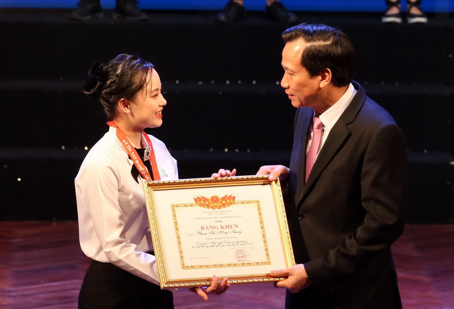 Bộ trưởng Bộ Lao động-Thương binh và Xã hội Đào Ngọc Dung trao Bằng khen của Bộ trưởng cho các thí sinh đạt Huy chương Vàng Kỳ thi Tay nghề Quốc gia lần thứ 10 năm 2018 tại Lễ tổng kết. (Ảnh: Anh Tuấn/TTXVN)