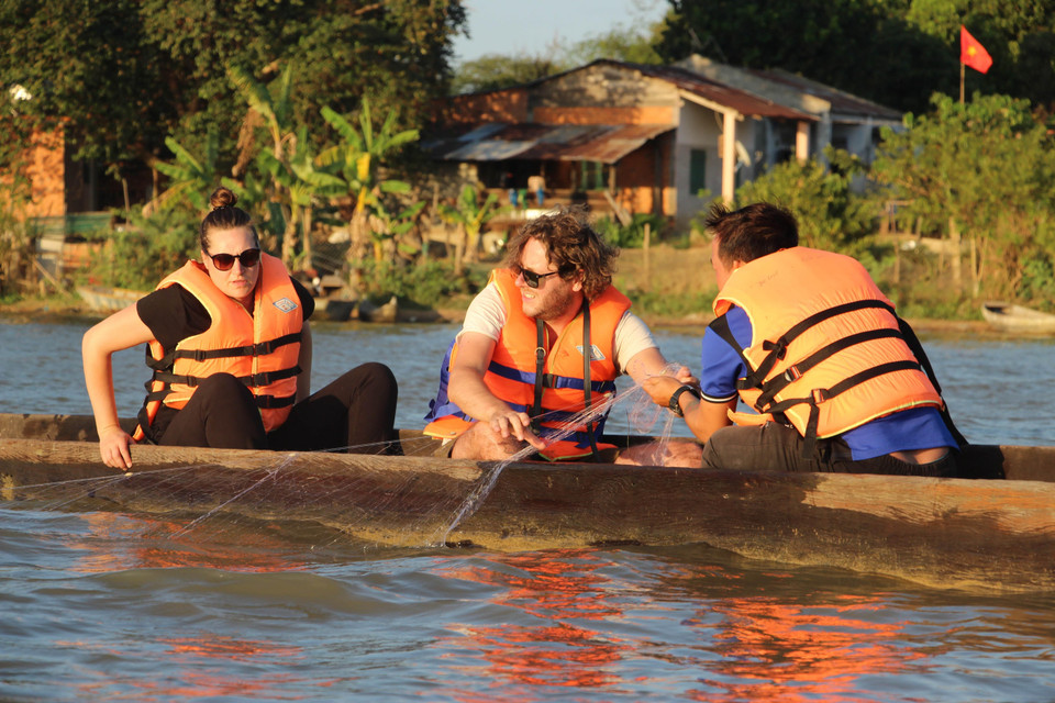 Du khách trải nghiệm đánh cá trên Hồ Lắk bằng thuyền độc mộc. (Ảnh: Nguyễn Tuấn Anh/TTXVN)
