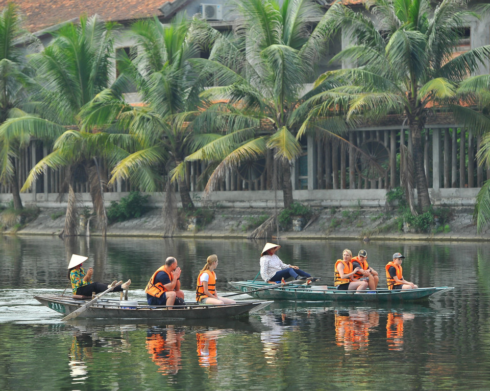 Du khách nước ngoài thích thú khi tham quan Tam Cốc bằng thuyền. (Ảnh: Minh Đức/TTXVN)