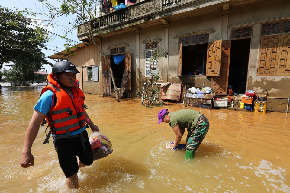 Một số nơi ở Lệ Thủy nước đã rút, người dân tranh thủ dọn dẹp vệ sinh nhà cửa. (Ảnh: Thành Đạt/TTXVN)