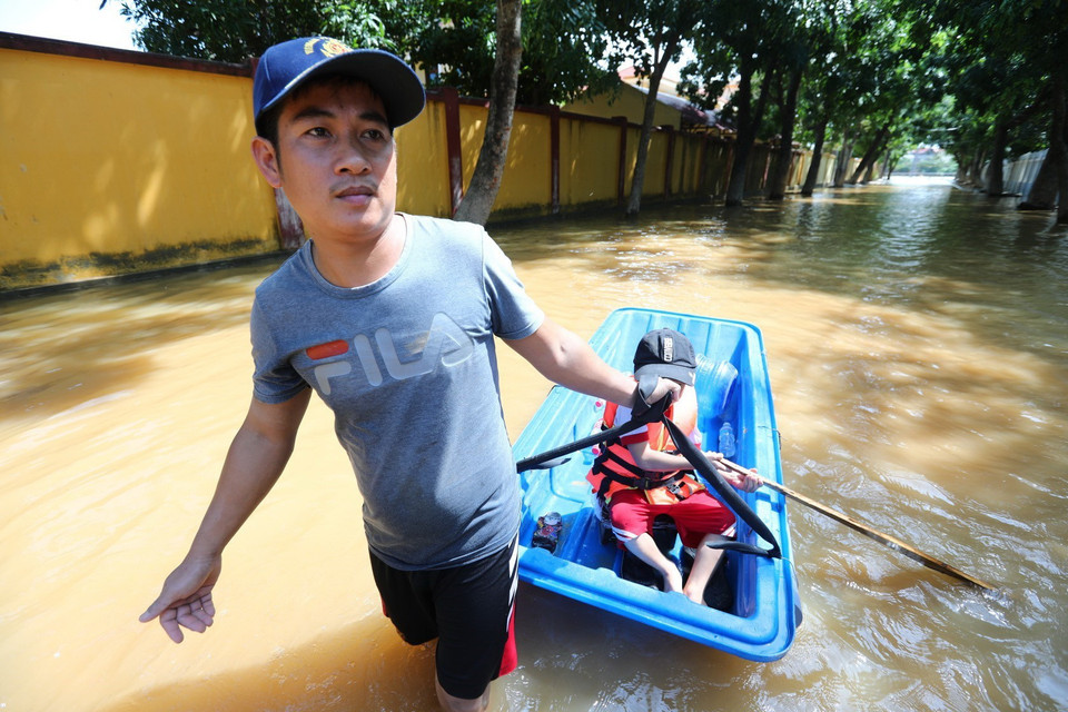 Nước rút dần, người dân rời nhà để tìm thực phẩm, nước uống. (Ảnh: Thành Đạt/TTXVN)